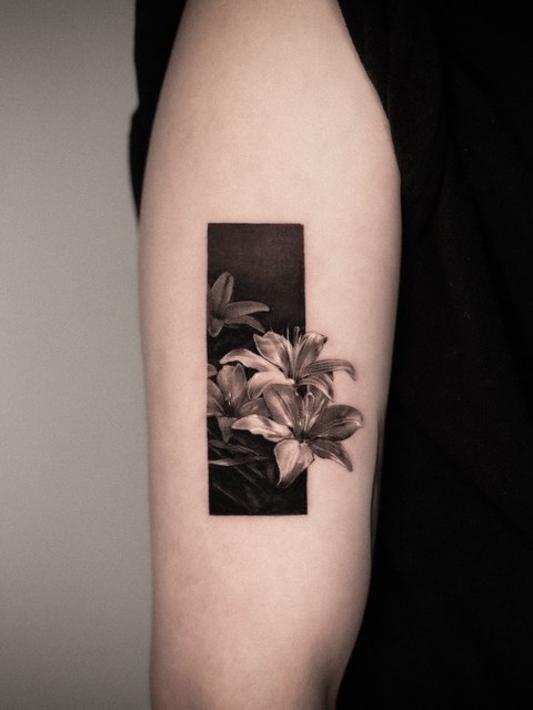 framed lily tattoo on the arm