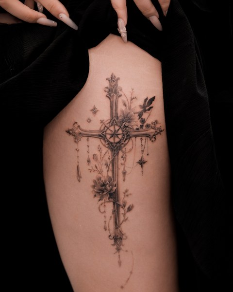 ornate cross and flowers tattoo on the back