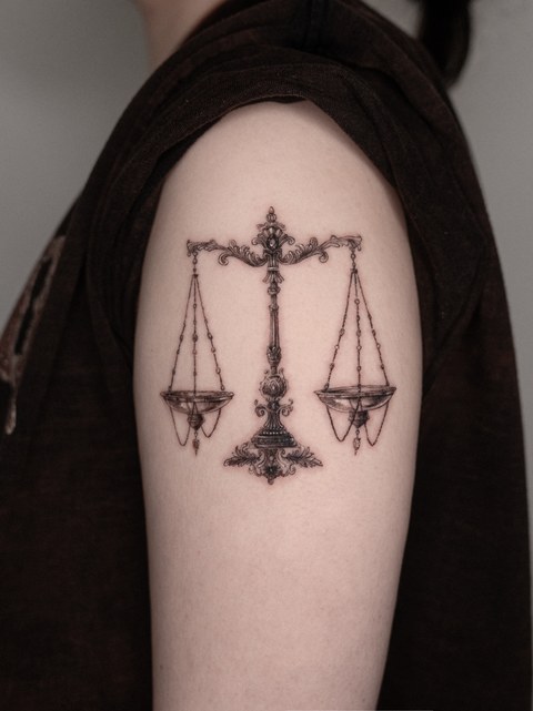 scales tattoo on the upper arm