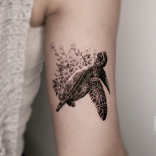 sea turtle and flowers tattoo on the arm
