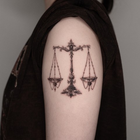 scales tattoo on the upper arm