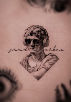classical bust and script lettering tattoo on the arm