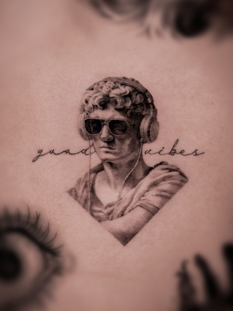 classical bust and script lettering tattoo on the arm