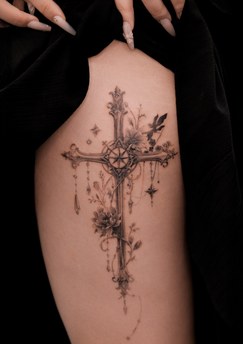 ornate cross and flowers tattoo on the back