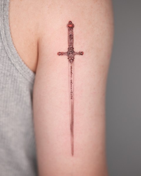 dagger tattoo on the inner arm