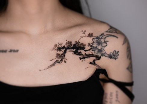 plum blossom cover up tattoo on the collarbone