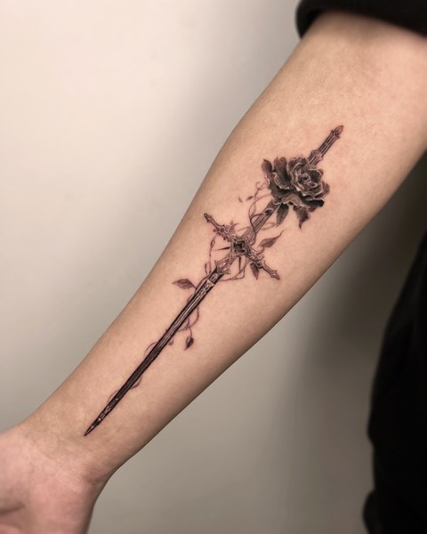 sword and flowers tattoo on the forearm