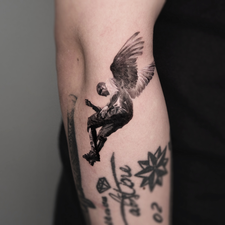 winged figure tattoo on the upper arm