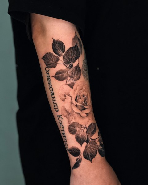 roses and lettering tattoo on the forearm