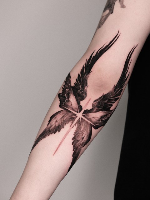 angel wing and star tattoo on the forearm