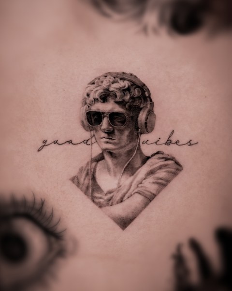 classical bust and script lettering tattoo on the arm