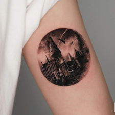 circular cityscape tattoo on the arm