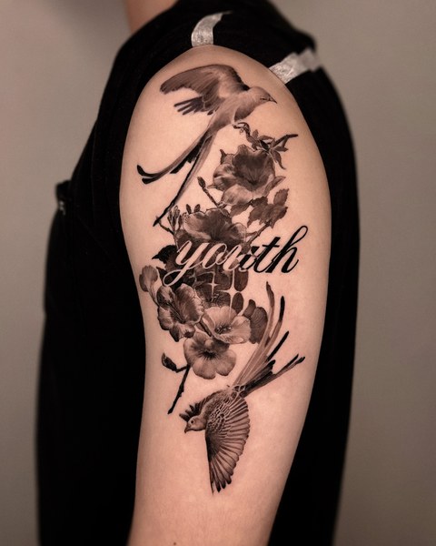 flowers and lettering tattoo on the upper arm