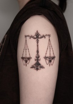 scales tattoo on the upper arm