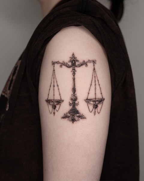 scales tattoo on the upper arm