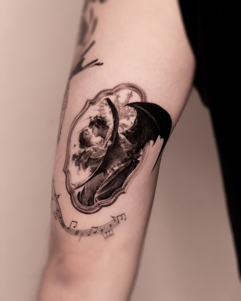 skull, flowers and lettering tattoo on the arm