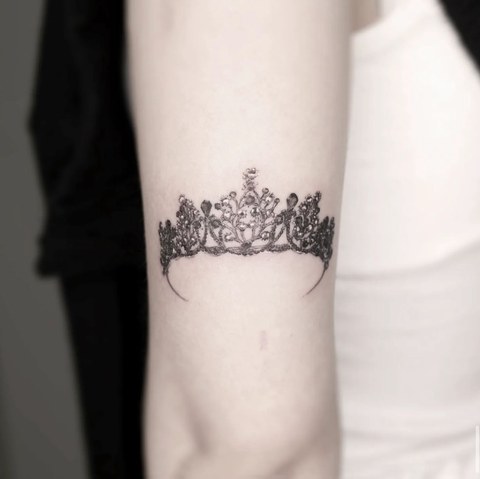 crown tattoo on the forearm