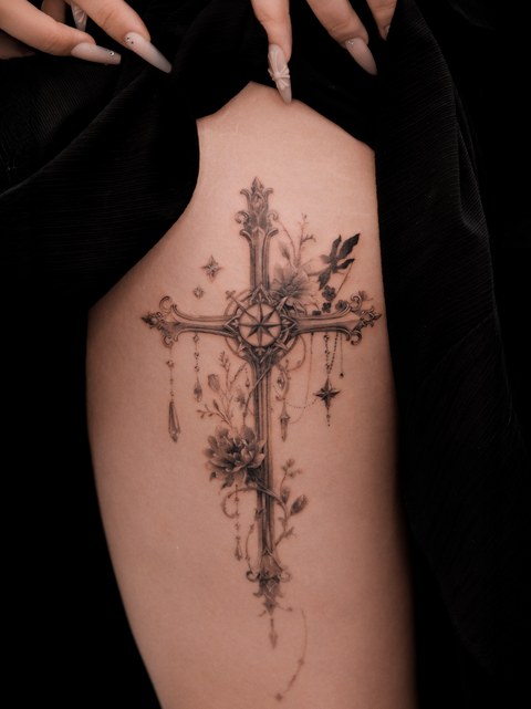 ornate cross and flowers tattoo on the back