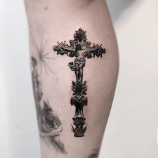 ornate crucifix tattoo on the arm